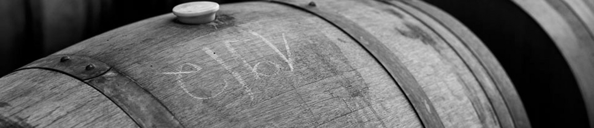 Black and white close-up of an oak wine barrel with a bung stopper and chalk markings, Chateau Yering cellar
