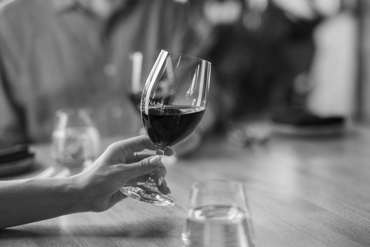 Woman swirls red Xanadu wine in glass