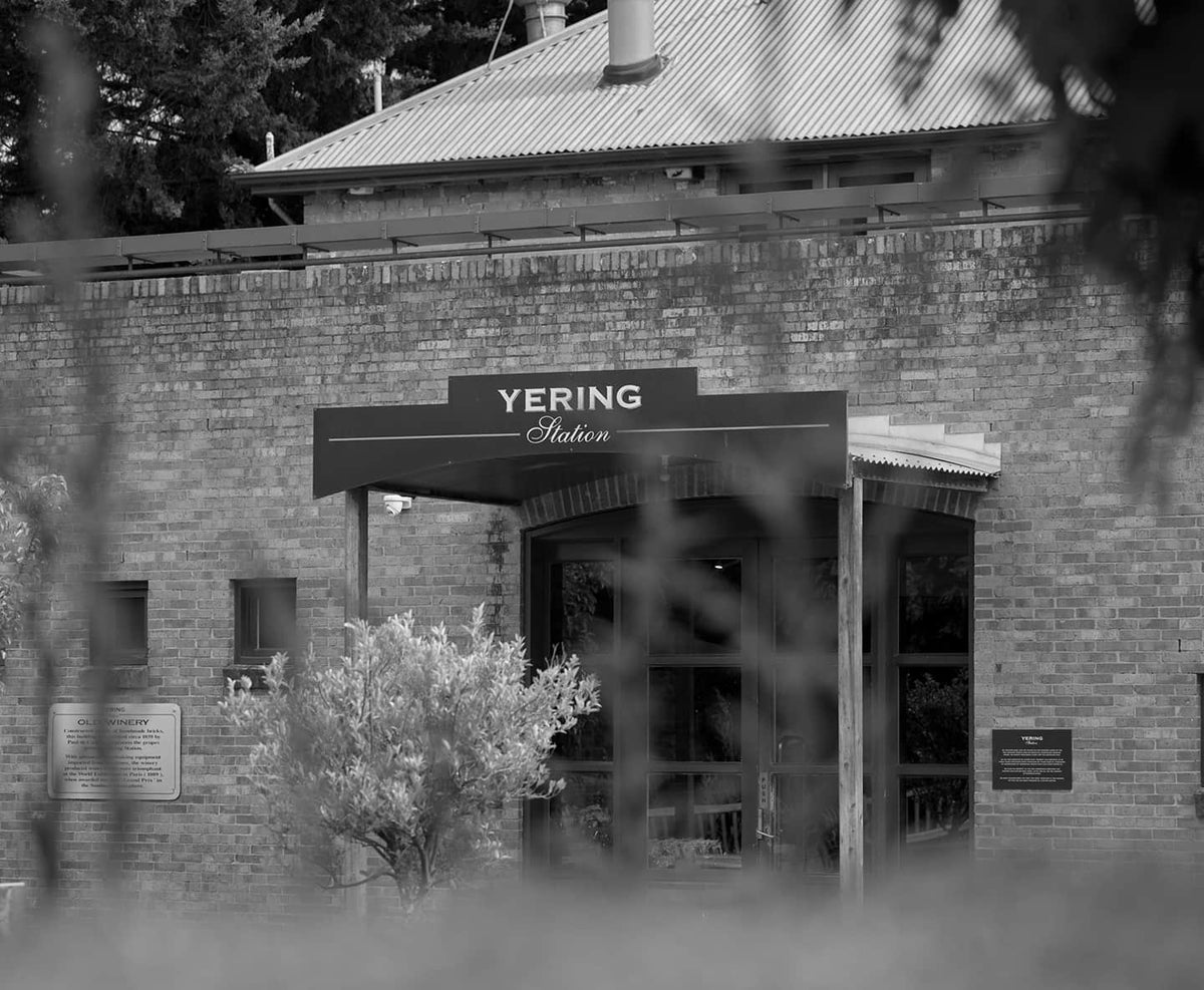 Black and white photo of the Yering Station cellar door entrance, brick building with signage
