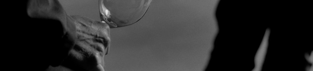 Black and white close-up of a hand holding a wine glass, sign-up hero banner